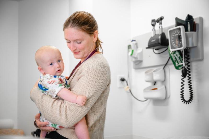 a nurse practitioner holding a baby