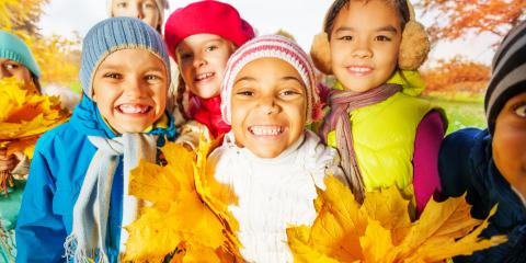 a group of kids wearing hats and holding fall leaves